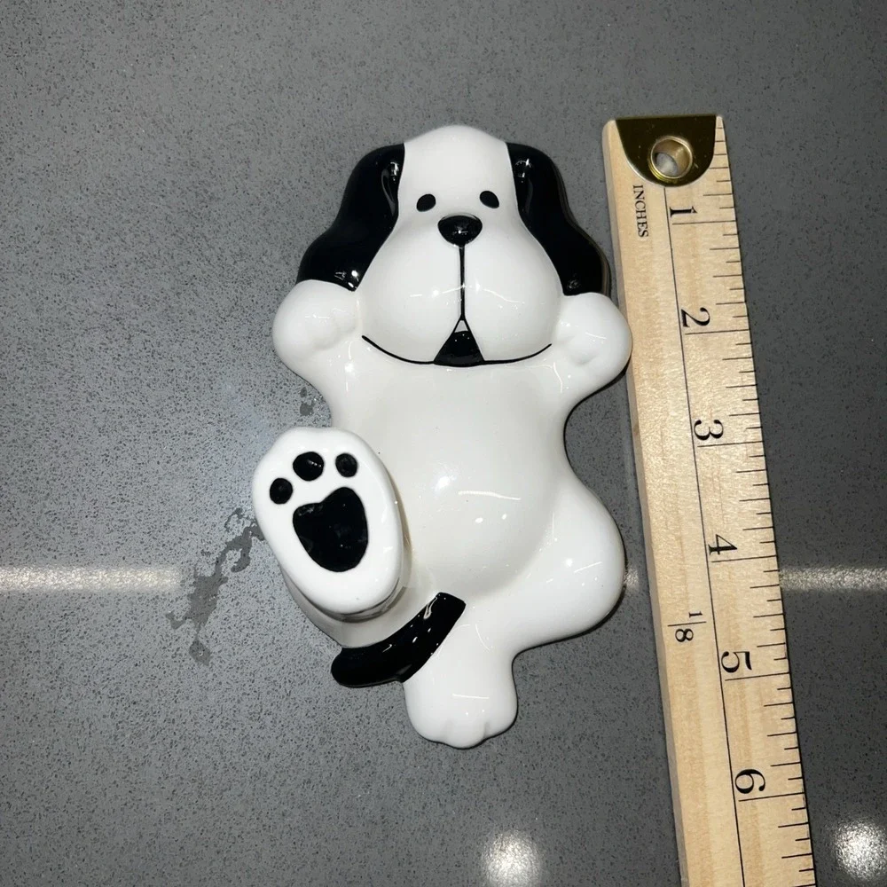 Two black-and-white dog wall hooks